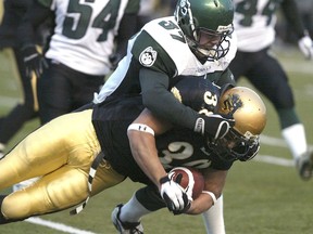 Manitoba Bisons fullback Neil Fulgueras is hauled down by Saskatchewan Huskies linebacker Chad Guidinger during the Canada West football final in Winnipeg on Nov. 11, 2006. It was the last time the teams met in a conference final. They'll resume that rivalry in the title match this coming Saturday.