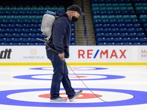 Greg Ewasko, the head ice-maker for the upcoming Olympic curling trials, works on the rings at SaskTel Centre.