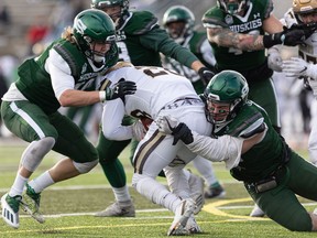 A pair of Huskies make the tackle during the team's conference-title win over Manitoba.