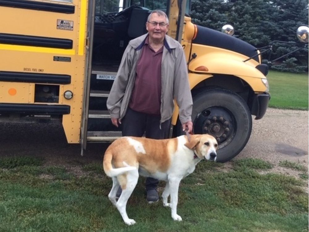  Adam Wosminity poses with his dog, Sara, near the school bus he drove in the fall of 2019 on his farm near Kamsack. Wosminity died of COVID-19 in March of 2020, the second death attributed to the pandemic in Saskatchewan. (Photo courtesy Jason Wosminity)