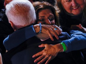 A woman hugs U. S. President Joe Biden as he campaigns for Democratic candidate for governor of Virginia Terry McAuliffe at a rally in Arlington, Virginia, U. S. Oct. 26, 2021.