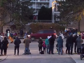 In this screenshot, a red vehicle can be seen driving through a parade route In Waukesha, Wisconsin.