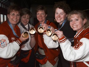 Sandra Schmirler (left), Marcia Gudereit, Jan Betker, Joan McCusker and Atina Ford show off their Olympic gold medals after landing in Calgary on their return to Canada from Japan in 1998.