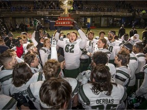 Huskies' offensive lineman Nicholas Summach lifts the trophy after defeating the University of Montreal Carabins in Saturday's Uteck Bowl.