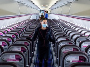 Bloomberg Best of the Year 2020: A member of the cabin crew wearing a protective face mask checks cabin seating ahead of the flight on-board a passenger aircraft operated by Wizz Air Holdings Plc at Liszt Ferenc airport during the Covid-19 pandemic in Budapest, Hungary, on Monday, May 25, 2020