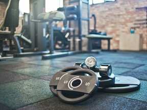 Barbell, dumbbells lie on the floor against the background of the gym.