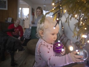 Austin Davis, his wife Melanie Metcalf and their daughter Evelyn and dog Bermie gather in their family room on Tuesday, Dec. 21, 2021 in Regina.