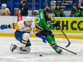 Saskatoon Blades forward Tristen Robins (11) and Prince Albert Raiders defence Landon Kosior (12) battle for the puck during fWHL action at SaskTel Centre in Saskatoon on Thursday, December 30, 2021.