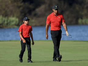 Tiger Woods and Charlie Woods walk down the 18th hole during the final round of the PNC Championship at the Ritz Carlton Golf Club Grande Lakes on December 19, 2021 in Orlando, Florida.