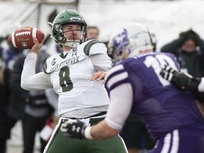 Saskatchewan Huskies quarterback Mason Nyhus throws a ball as Western's Nicolas Theriault defends during second-quarter action at Saturday's Vanier Cup in Quebec City.