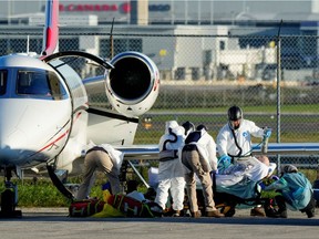 Medical personnel transfer a patient from an air ambulance which departed Regina, Saskatchewan to a waiting ambulance at Pearson International Airport in Mississauga, Ontario, Canada October 27, 2021.