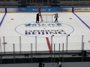 FILE PHOTO: Staff members move a net as they maintain the rink, at an ice hockey competition venue for the 2022 Olympic Winter Games, inside the National Indoor Stadium,  in Beijing, China April 1, 2021. REUTERS/Tingshu Wang/File Photo