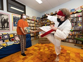 Kirtis Crowe, left, and Revered Mark Kleiner karate chop some VHS tapes in the Nutflakes video rental store in the basement of Christ Church Anglican in Caswell Hill.