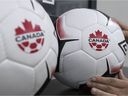 An employee adjusts balls at Soccer Canada Headquarters in Ottawa, Ontario as Canada will co-host the 2026 World Cup with Mexico and the US. The 2026 World Cup is to be hosted by Canada, Mexico and the United States. (Photo by Lars Hagberg / AFP)
