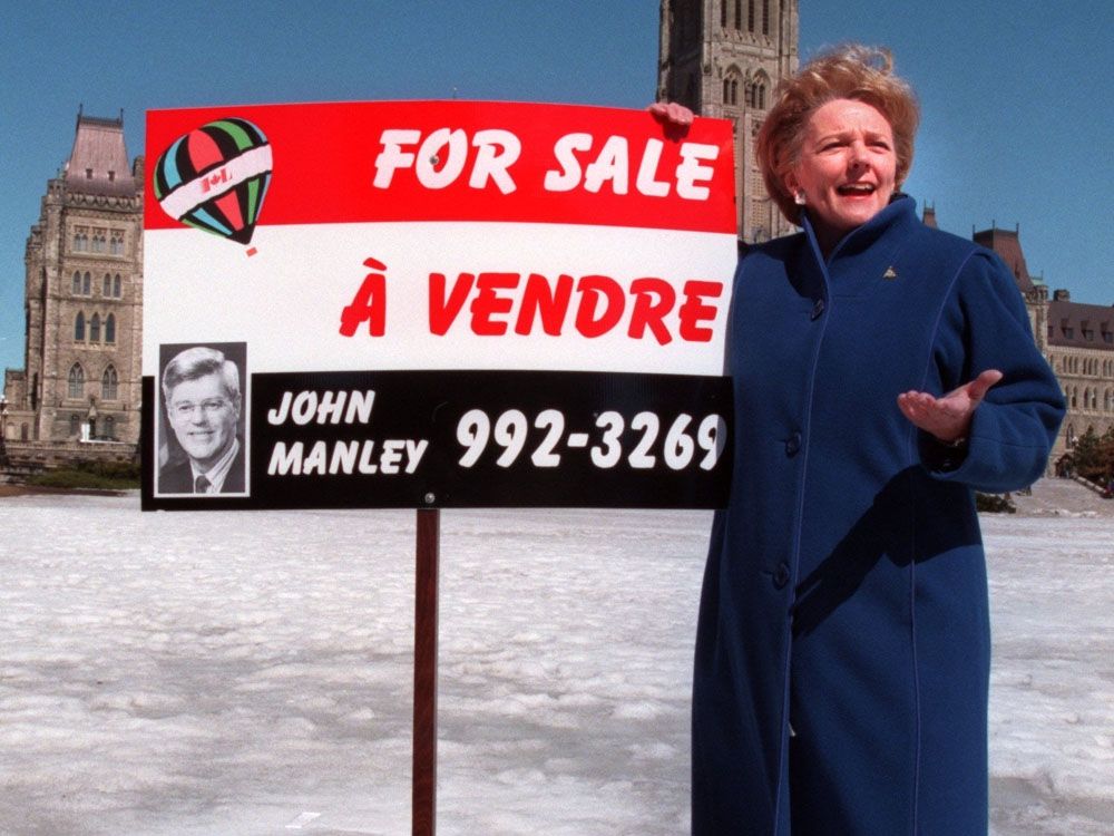 Federal NDP Leader Alexa McDonough displays a sign that likens Minister John Manley to a real estate salesman on Parliament Hill, Tuesday, March 30, 1999.