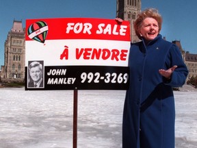 Federal NDP Leader Alexa McDonough displays a sign that likens Minister John Manley to a real estate salesman on Parliament Hill, Tuesday, March 30, 1999.