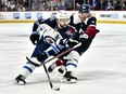 Colorado Avalanche right wing Nicolas Aube-Kubel (16) reaches in with his stick on Winnipeg Jets defenseman Josh Morrissey (44) as he controls the puck during the third period at Ball Arena. Mandatory Credit: John Leyba-USA TODAY Sports