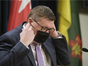 Premier Scott Moe puts a mask on during a press conference at the Legislative Building. MICHAEL BELL / Regina Leader-Post