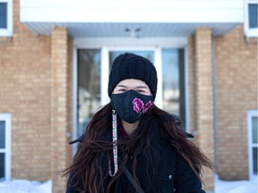 Uyen Huynh stands outside the apartment building that was her first home when she arrived in Saskatoon as a four-year-old after fleeing Vietnam with her family.