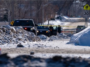 Police vehicles line up near the intersection of 22nd Street West and Avenue U South in Saskatoon, Sask. on Feb. 23, 2022.