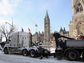 A protester's truck is towed away after police cleared the street of demonstrators in Ottawa, Ontario, Canada, on February 19, 2022. - Police pushed into downtown Ottawa Saturday in a bid to dislodge several hundred dug-in protesters and big rigs that have choked the Canadian capital for weeks, after a night marked by clashes and more than 100 arrests