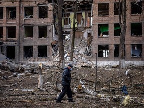 A man walks in front of a destroyed building after a Russian missile attack in the town of Vasylkiv, near Kyiv, on February 27, 2022.