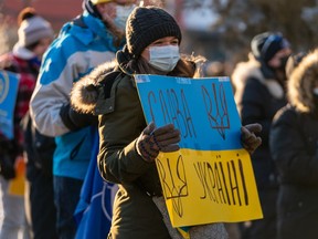 A participant holds a sign during a rally in support of Ukraine in front of city hall in Saskatoon, Sask. on Wednesday, February 23, 2022.