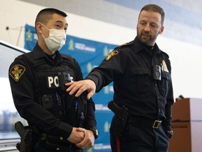 Const. Al Chan (left) and Sgt. Tom Gresty demonstrate the body-worn cameras that 40 members of the Saskatoon Police Service will be wearing as part of their pilot project.