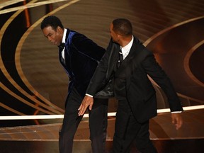 Actor Will Smith, right, slaps actor Chris Rock onstage during the 94th Oscars at the Dolby Theatre in Hollywood on Sunday, March 27, 2022.