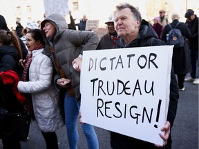 A man holds a placard as he takes part in a protest outside Downing Street during Canadian Prime Minister Justin Trudeau's visit, following Russia's invasion of Ukraine, in London, Britain, March 7, 2022. REUTERS/Henry Nicholls