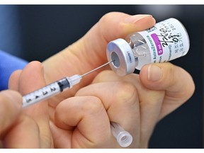 A nurse fills a syringe with the AstraZeneca COVID-19 vaccine