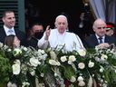 Pope Francis, centre, flanked by Malta's Prime Minister, Robert Abela, left, and Malta's President, George Vella, right, waves from the balcony of the presidential Palace on April 2, 2022 in Valletta, Malta, on the first day of the Pope's two-day trip to the Mediterranean archipelago.