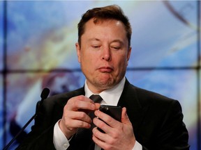 Elon Musk looks at his mobile phone in Cape Canaveral, Florida, U.S. January 19, 2020. REUTERS/Joe Skipper/File Photo