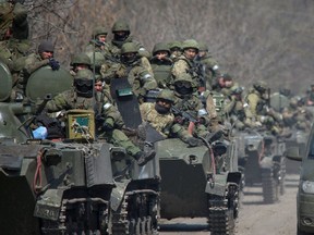 Service members of pro-Russian troops ride on armoured vehicles in the course of Ukraine-Russia conflict on a road leading to the city of Mariupol, Ukraine on April 15.