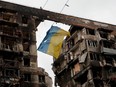A view shows a torn flag of Ukraine hung on a wire in front an apartment building destroyed during Ukraine-Russia conflict in the southern port city of Mariupol, Ukraine April 14, 2022.