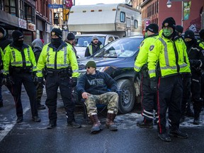 Ottawa Police Service members accompany Ottawa bylaw officers as they issued parking tickets and fines during the 'Freedom Convoy' protest in the city's downtown core.