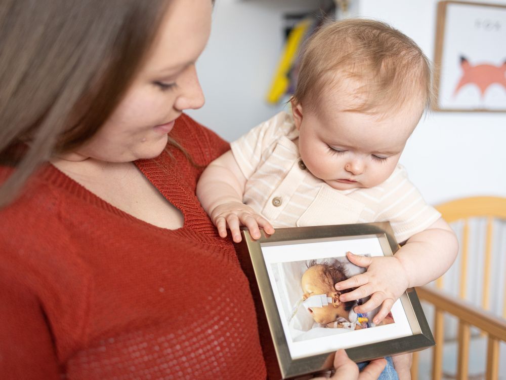 Rustee Tosh holds her eight-month-old daughter Ellie Mae and a photo of her first born son Henry who died in hospital on March 10, 2019 from an infection, after undergoing four open-heart surgeries, before they could ever bring him home. "We're so happy. But also really sad at the same time. He'd be three years old and he'd be a good big brother. She hits milestones and we think about how Henry never got to experience those. So that's hard," she says.