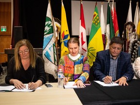Saskatchewan Social Services Minister Lori Carr, Assistant Deputy Minister of Disability Programs and Housing Louise Michaud, andTribal Chief Mark Arcand (left to right) sign an agreement document at a press conference to announce a partnership between the Saskatoon Tribal Council and the provincial government to pilot a wellness centre in Saskatoon.