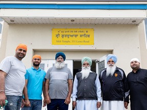 Volunteers stand outside the Sikh temple as they prepare for Saturday's Khalsa Day parade.