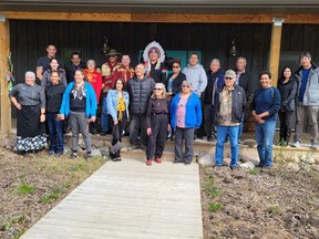 Le chef Blaine Fiddler et les aînés de la Première Nation de Waterhen Lake se tiennent avec le personnel du Waters Edge Eco Lodge et les membres de la société de développement de la Première Nation de Waterhen Lake le 20 mai 2022.
