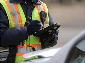 A parking enforcement staff member for the city of Saskatoon prints out a ticket for a vehicle parked downtown in Saskatoon on April 26, 2017.