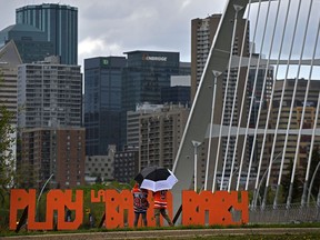 People check out the large letters spelling out Play La Bamba next to the Walterdale Bridge in Edmonton, May 24, 2022.