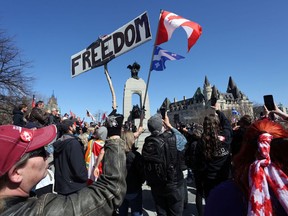 A protester holds up a freedom sign during a ceremony at the National War Memorial during the Rolling Thunder Convoy on April 30, 2022 in Ottawa, Canada.
