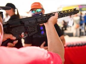 A customer holds an TPM Arms LLC California-legal featureless AR-15 style rifle displayed for sale at the company's booth at the Crossroads of the West Gun Show at the Orange County Fairgrounds on June 5, 2021 in Costa Mesa, California.