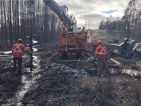 SaskPower and contractor crews working to restore power to northern Saskatchewan after poles were damaged in a wildfire that started northeast of Prince Albert on May 17, 2021. Photo provided by SaskPower. (StarPhoenix)