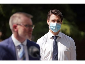 Canada's Prime Minister Justin Trudeau, right, looks on as Saskatchewan Minister of Mental Health and Addictions, Seniors, and Rural and Remote Health Everett Hindley speaks during a media event at St. Ann's Senior Citizens' Village Corporation in Saskatoon, Saskatchewan, Canada May 25, 2022.