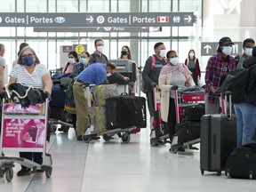 People wait in line to check in at Pearson International Airport in Toronto on May 12, 2022.