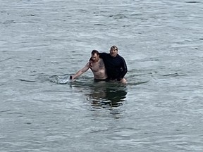 Brian Gibson escorts a man out of the South Saskatchewan River on April 27, 2022. Photo provided by Harvey Weber
