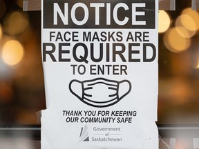 This sign in the window of a business in Saskatoon, Sask. shows face masks are required on Monday, January 31, 2022.