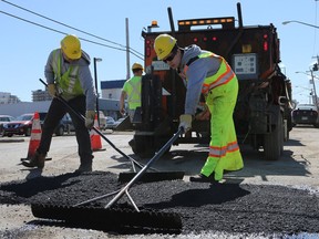 City of Saskatoon workers fill a pothole at the corner of First Avenue North and King Street in Saskatoon in April of 2017. (Michelle Berg/Saskatoon StarPhoenix)